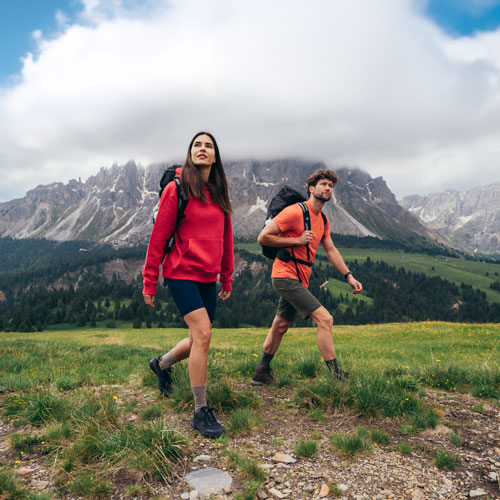Auf dem Bild sind ein Mann und eine Frau zu sehen, die durch die Natur wandern